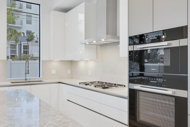 201 SE 4th Ave, Delray Beach, FL 33483 - kitchen with a sink, wall chimney exhaust hood, double wall oven, stainless steel gas cooktop, and modern cabinets