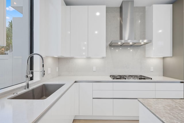 201 SE 4th Ave, Delray Beach, FL 33483 - kitchen featuring wall chimney exhaust hood, modern cabinets, a sink, and stainless steel gas stovetop