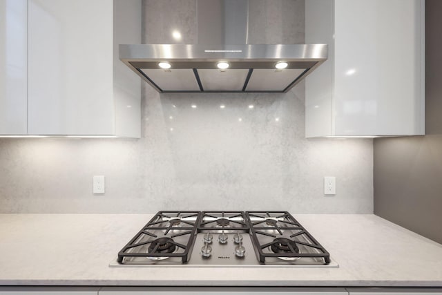 201 SE 4th Ave, Delray Beach, FL 33483 - kitchen featuring ventilation hood, stainless steel gas cooktop, white cabinetry, and modern cabinets