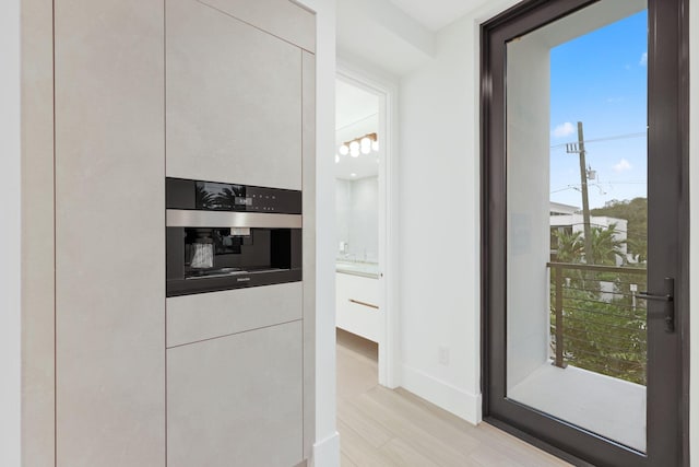 201 SE 4th Ave, Delray Beach, FL 33483 - kitchen featuring stainless steel oven, white cabinets, baseboards, and modern cabinets