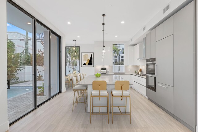 201 SE 4th Ave, Delray Beach, FL 33483 - kitchen featuring modern cabinets, healthy amount of natural light, a kitchen island, white cabinetry, and recessed lighting
