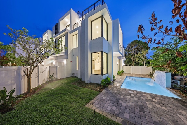 201 SE 4th Ave, Delray Beach, FL 33483 - back of house at twilight featuring stucco siding, a patio, and a balcony