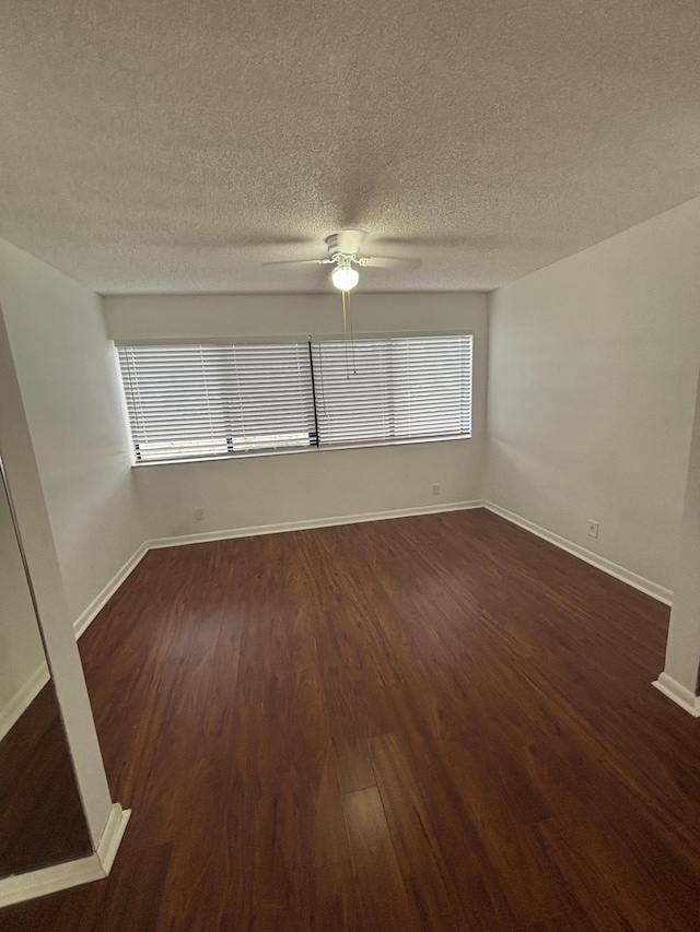 4820 Lucerne Lakes Blvd W Unit 107, Greenacres, FL 33467 - unfurnished room with dark wood finished floors, a textured ceiling, plenty of natural light, a ceiling fan, and baseboards