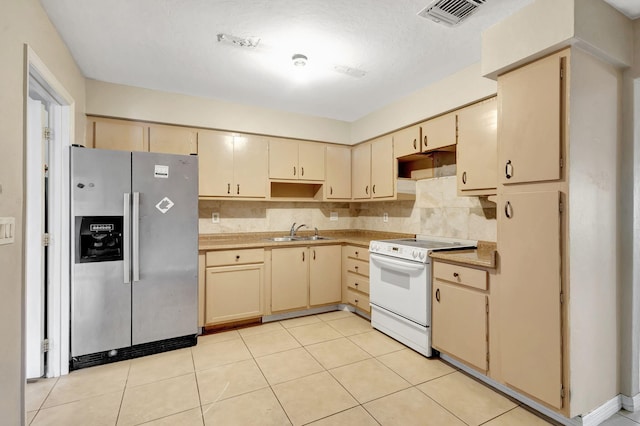 3854 Van Cott Cir, West Palm Beach, FL 33403 - kitchen featuring stainless steel fridge, white range with electric cooktop, a sink, backsplash, and cream cabinetry