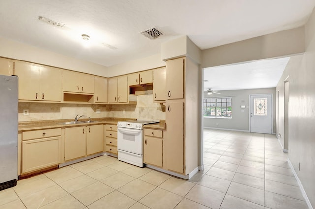 3854 Van Cott Cir, West Palm Beach, FL 33403 - kitchen with electric range, cream cabinets, a sink, freestanding refrigerator, and light tile patterned floors