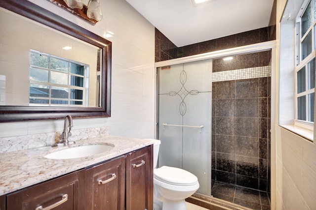 3854 Van Cott Cir, West Palm Beach, FL 33403 - bathroom featuring tile walls, a stall shower, vanity, and toilet