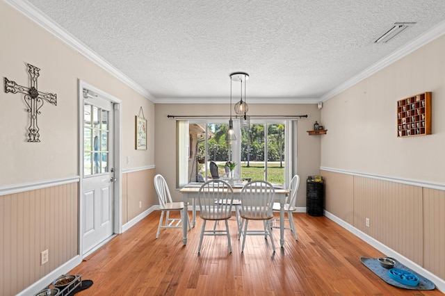 11447 Orange Grove Blvd, West Palm Beach, FL 33411 - dining room with hardwood / wood-style flooring, crown molding, a textured ceiling, and baseboards