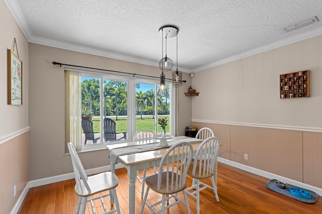 11447 Orange Grove Blvd, West Palm Beach, FL 33411 - dining area featuring wood finished floors, a textured ceiling, ornamental molding, a wainscoted wall, and baseboards