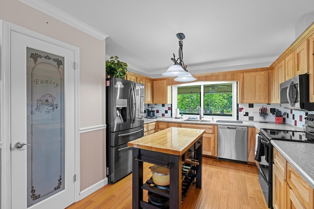 11447 Orange Grove Blvd, West Palm Beach, FL 33411 - kitchen with appliances with stainless steel finishes, light wood-style floors, a sink, decorative backsplash, and ornamental molding