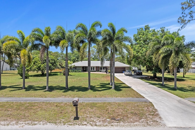 11447 Orange Grove Blvd, West Palm Beach, FL 33411 - ranch-style home featuring a front lawn, an attached garage, and driveway