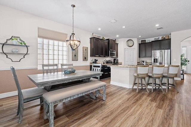 7267 Prudencia Dr, Lake Worth, FL 33463 - dining area with light wood finished floors, arched walkways, a chandelier, and recessed lighting