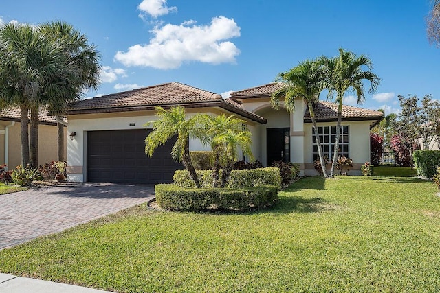 7267 Prudencia Dr, Lake Worth, FL 33463 - mediterranean / spanish-style home with an attached garage, a tile roof, decorative driveway, stucco siding, and a front yard