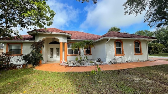 2332 SW Savona Blvd, Port Saint Lucie, FL 34953 - mediterranean / spanish home with a tiled roof, stucco siding, and a front lawn