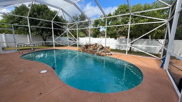 2332 SW Savona Blvd, Port Saint Lucie, FL 34953 - view of pool with a fenced backyard, a patio, and glass enclosure