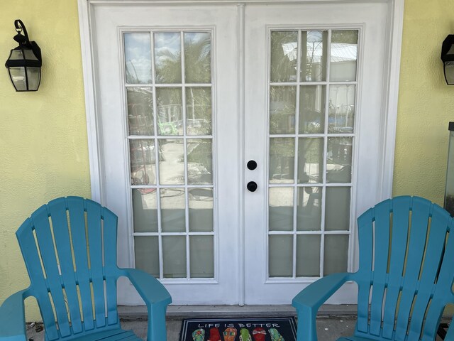 1099 7th St, Okeechobee, FL 34974 - view of exterior entry featuring french doors, stucco siding, and a gate