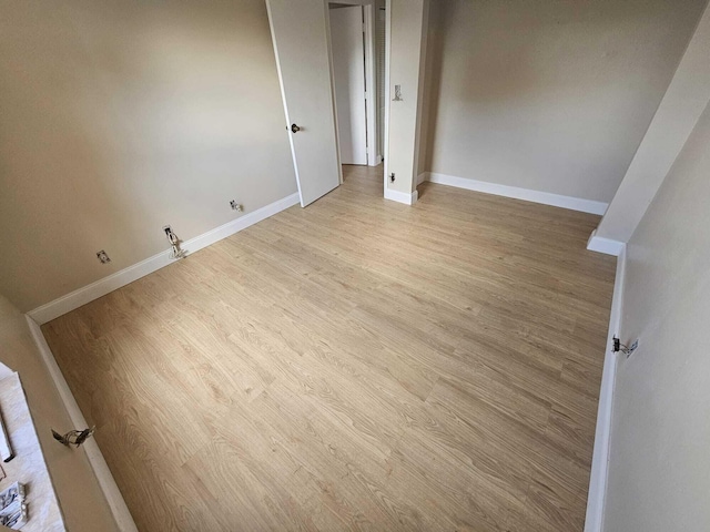 empty room with light wood finished floors and baseboards