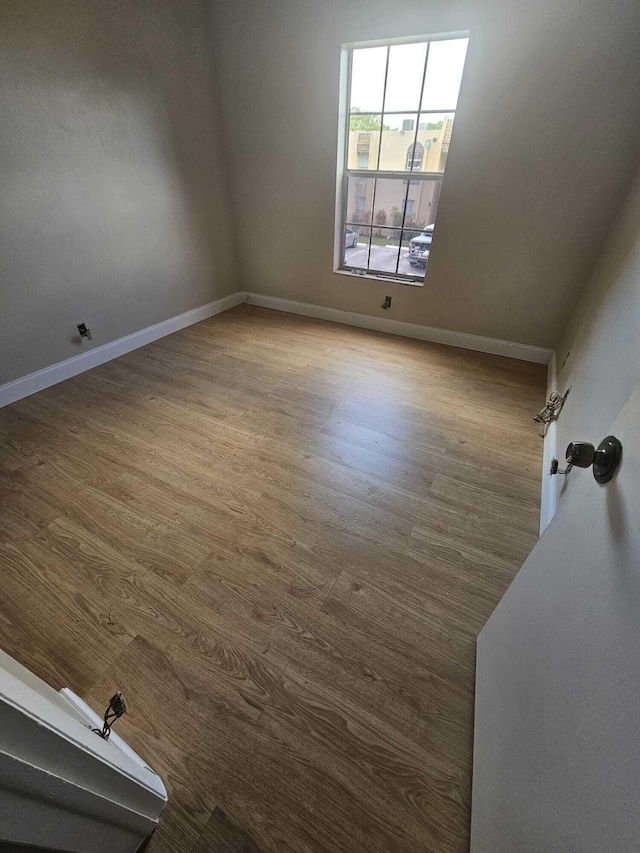 unfurnished room with wood finished floors and baseboards