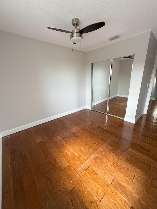 310 SE 2nd Ave Unit A3, Deerfield Beach, FL 33441 - unfurnished bedroom featuring hardwood / wood-style floors, a closet, baseboards, a ceiling fan, and a textured ceiling