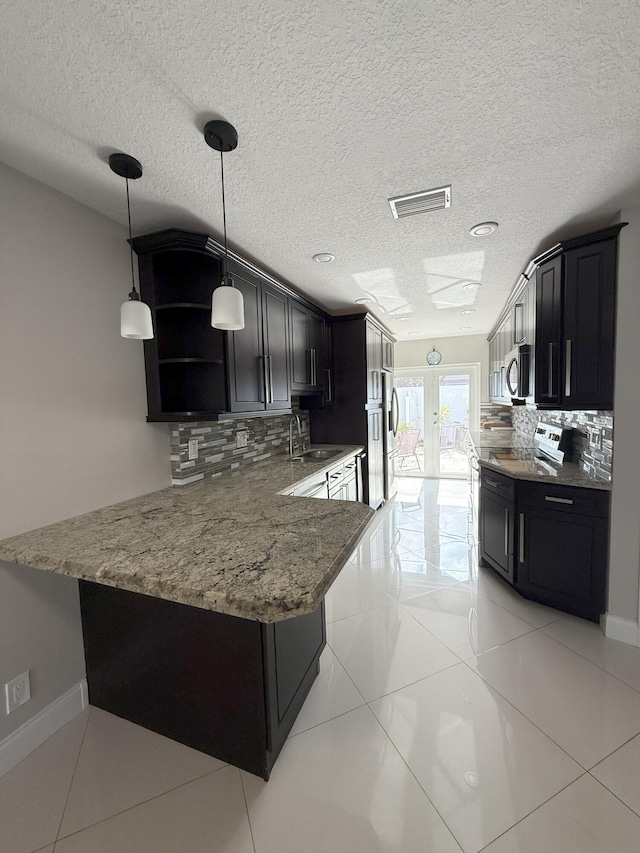 310 SE 2nd Ave Unit A3, Deerfield Beach, FL 33441 - kitchen with appliances with stainless steel finishes, a sink, tasteful backsplash, dark cabinets, and a textured ceiling
