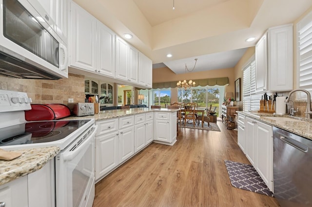 2596 Irma Lake Dr, West Palm Beach, FL 33411 - kitchen featuring white appliances, a sink, white cabinetry, light wood-style flooring, and a chandelier