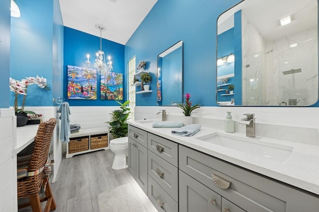 2596 Irma Lake Dr, West Palm Beach, FL 33411 - full bath with a marble finish shower, wainscoting, toilet, double vanity, and lofted ceiling