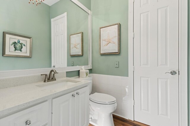 2596 Irma Lake Dr, West Palm Beach, FL 33411 - bathroom featuring vanity, toilet, a wainscoted wall, tile walls, and wood finished floors