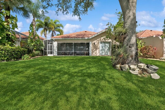 2596 Irma Lake Dr, West Palm Beach, FL 33411 - rear view of house with a tiled roof, a yard, and stucco siding