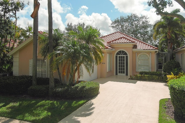 2596 Irma Lake Dr, West Palm Beach, FL 33411 - mediterranean / spanish-style house featuring stucco siding, a tiled roof, and concrete driveway