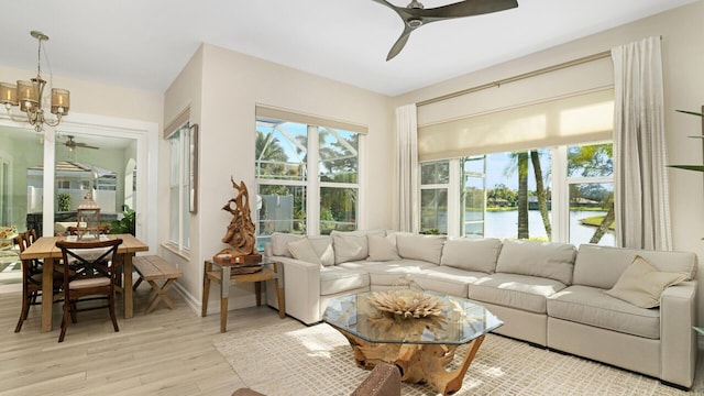 6193 Winding Lake Dr, Jupiter, FL 33458 - living room featuring ceiling fan, light wood-style flooring, a water view, and a chandelier