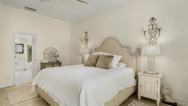 6193 Winding Lake Dr, Jupiter, FL 33458 - bedroom with wood finished floors, ensuite bath, and baseboards