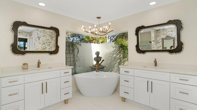 6193 Winding Lake Dr, Jupiter, FL 33458 - bathroom featuring two vanities, a chandelier, and a freestanding tub