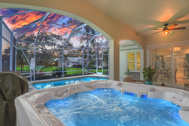 6193 Winding Lake Dr, Jupiter, FL 33458 - pool at dusk featuring a hot tub, a swimming pool, a ceiling fan, and a lanai