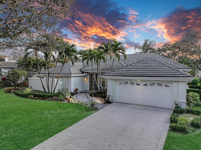6193 Winding Lake Dr, Jupiter, FL 33458 - view of front of home featuring a front lawn, driveway, a tile roof, and stucco siding