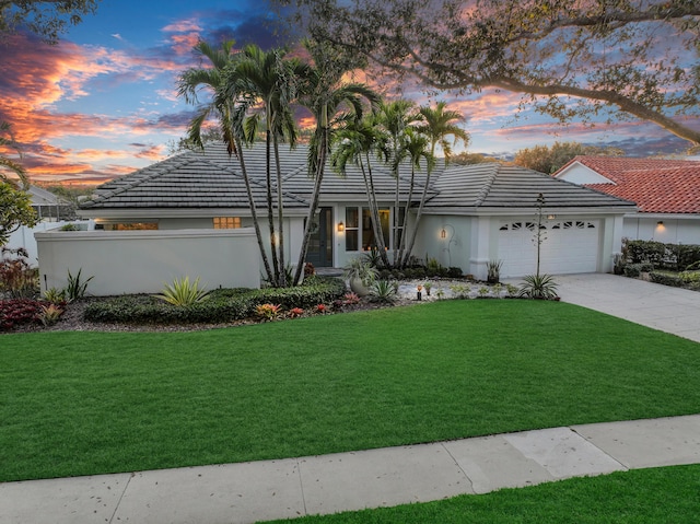 6193 Winding Lake Dr, Jupiter, FL 33458 - view of front of house with an attached garage, concrete driveway, stucco siding, and a tile roof