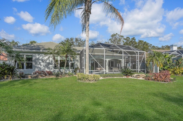 6193 Winding Lake Dr, Jupiter, FL 33458 - rear view of house with a lawn, stucco siding, and glass enclosure