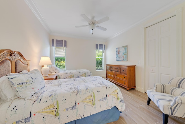 bedroom with ornamental molding, a closet, light wood-style floors, ceiling fan, and baseboards