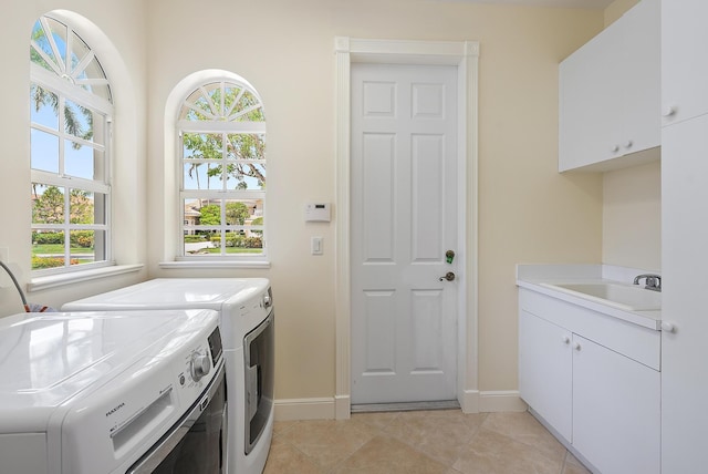 laundry room with cabinet space, separate washer and dryer, baseboards, and light tile patterned floors