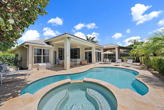 view of pool with a patio, a pool with connected hot tub, and an outdoor hangout area