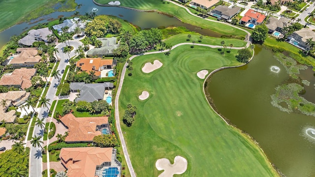 view of property location featuring nearby suburban area, a nearby body of water, and a golf club