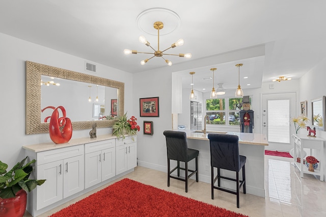 2403 Antigua Cir Unit M1, Coconut Creek, FL 33066 - kitchen featuring a peninsula, a chandelier, decorative light fixtures, and a breakfast bar area