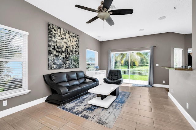 living area featuring a ceiling fan, baseboards, and wood finish floors