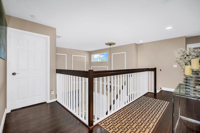 corridor featuring dark wood-style flooring, baseboards, and recessed lighting