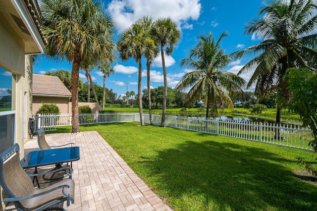 view of yard with a water view and a patio