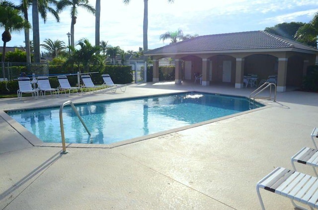 community pool featuring a patio and fence