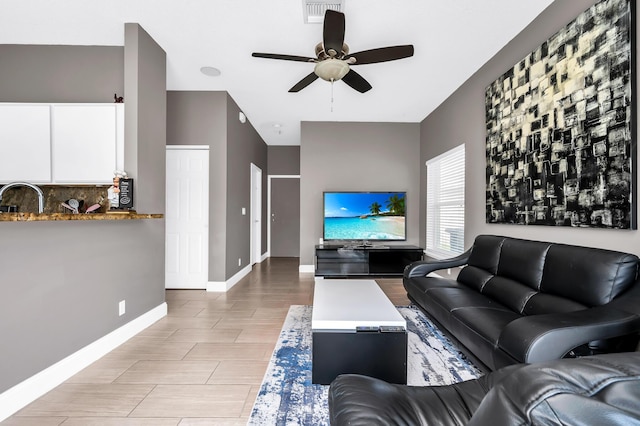 living room with ceiling fan and baseboards