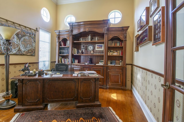 143 SE Bella Strano, Port Saint Lucie, FL 34984 - home office with wallpapered walls, wood-type flooring, a wainscoted wall, ornamental molding, and healthy amount of natural light