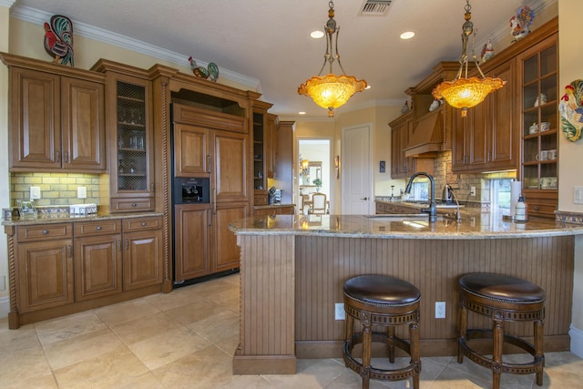 143 SE Bella Strano, Port Saint Lucie, FL 34984 - kitchen with paneled built in refrigerator, brown cabinets, light stone countertops, a sink, and recessed lighting