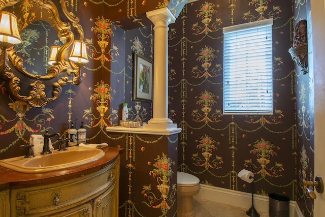 143 SE Bella Strano, Port Saint Lucie, FL 34984 - half bathroom featuring tile patterned floors, decorative columns, toilet, vanity, and wallpapered walls
