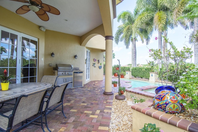 143 SE Bella Strano, Port Saint Lucie, FL 34984 - view of patio / terrace with exterior kitchen, a grill, ceiling fan, outdoor dining space, and a pool with connected hot tub