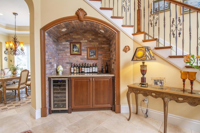 143 SE Bella Strano, Port Saint Lucie, FL 34984 - indoor dry bar featuring beverage cooler, stairs, a chandelier, and crown molding